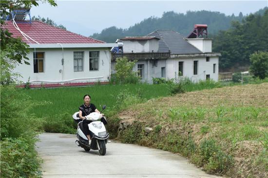 在安徽省岳西县来榜镇公山村,汪链骑车出行事情(6月24日摄)。新华社记者 周牧 摄
