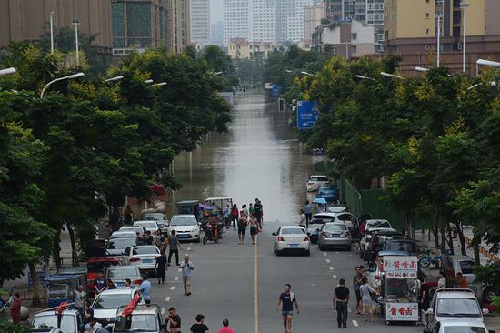 许多居民在淹没区边缘观望,等待水退