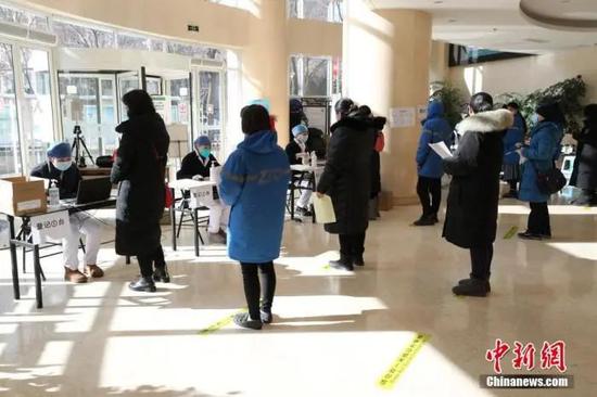 1月29日，在北京市海淀区学院路街道临时接种点内，等待接种疫苗的民众排队进行信息登记。中新社记者 蒋启明 摄