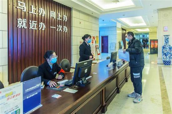 1月4日,武汉经开区市民服务中心,工作人员为前来办理业务人员解答问题。该区加快营造最优营商环境,实行一窗办理、同步预审,实现两个环节、一天办结、零费用。(湖北日报全媒记者 梅涛 摄)