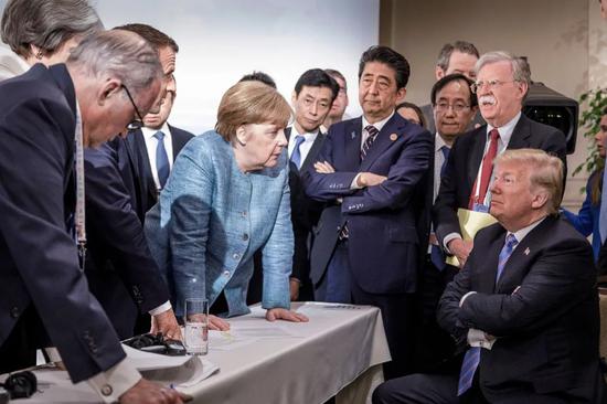 当地时间2018年6月9日,加拿大魁北克,G7峰会第二日,德国总理默克尔、法国总统马克龙、时任日本首相安倍晋三等多国领导人同特朗普谈话。/IC Photo