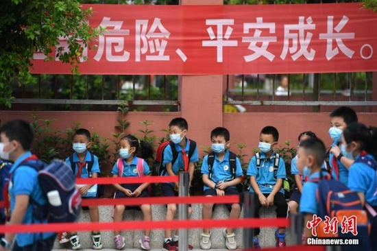 资料图：2020年9月1日，重庆市大渡口区双山实验小学的学生们戴着口罩有序进入校园。