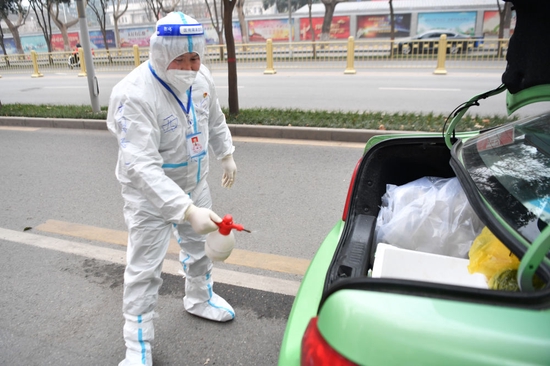 1月5日，西安“的哥”王锋利在出发转运核酸检测样本前为车辆消毒。新华社记者 张博文 摄