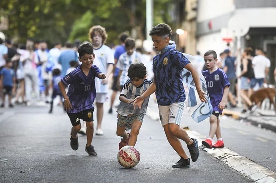 当地时间2022年12月18日，阿根廷，青少年球迷在街头踢球。图/视觉中国