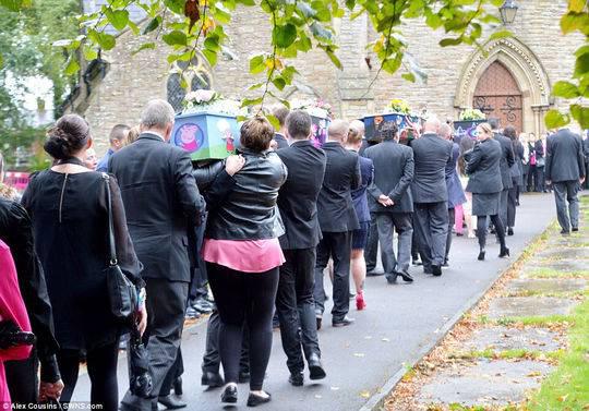 数百名悲痛欲绝的吊唁者身穿蓝色和粉色衣服，走上大曼彻斯特沃克登街头为孩子们送行。