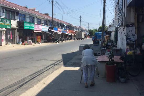  天平镇街头，一位老人费力地向前迈步。新京报记者陶若谷 摄