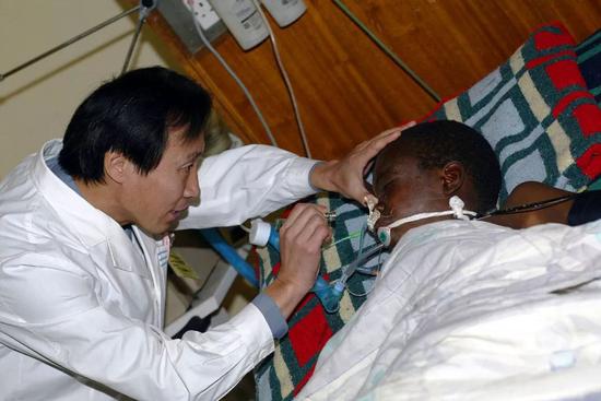 2007年8月15日，在赞比亚首都卢萨卡的大学教学医院，中国医疗队队长李彦伟为当地一名车祸伤员做检查。新华社记者王成云摄