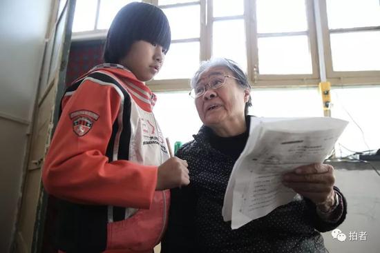“小课桌”上,严敏文正在解答小女孩儿提出的问题。新京报记者尹亚飞 摄
