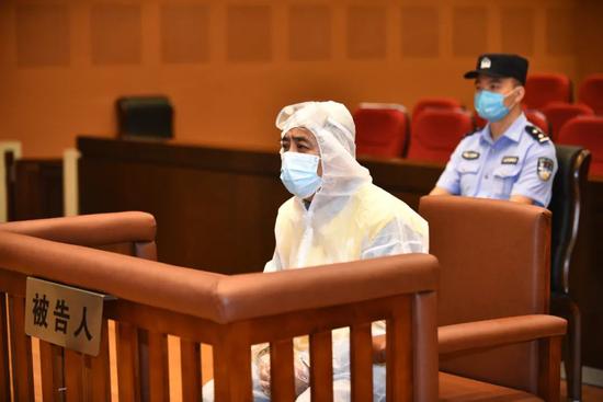庭审当日，被告人麻继钢着防护服到庭受审。