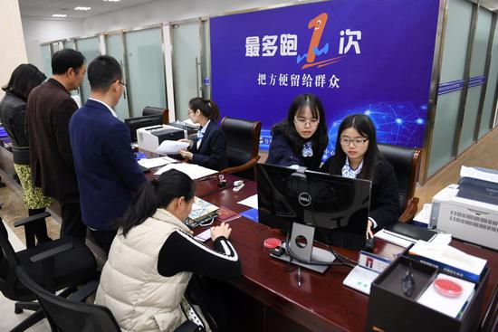 2018年3月28日,浙江省台州市行政办事中间的事情职员在给市民解决营业。适应人民群众呼声,浙江提出“最多跑一次”改造,表现以人民为中间的生长头脑。新华社记者 殷博古 摄