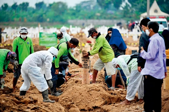 7月22日，印度尼西亚雅加达，人们在Rorotan公墓安葬新冠病逝者。图/人民视觉