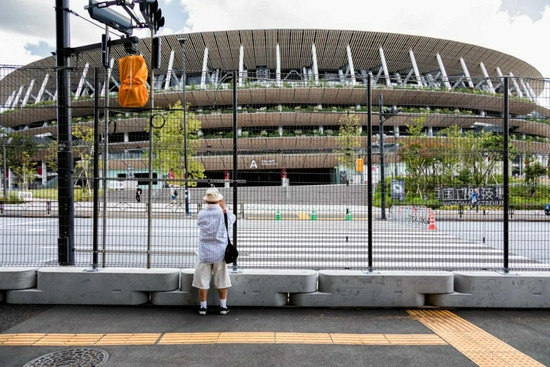 8月3日，日本东京，一名男子路过东京的国家奥林匹克体育场。/IC photo