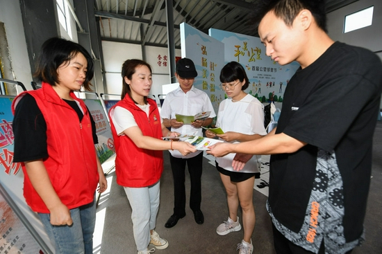 2021年9月26日,杭州市富阳区志愿者们在开展扫黄打非、防电信诈骗、扫黑除恶等安全知识宣传。新华社记者 徐昱 摄
