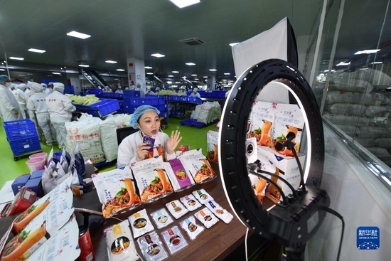 在广西一家螺蛳粉生产企业车间，工作人员在直播销售螺蛳粉（6月17日摄）。新华社记者 黄孝邦 摄