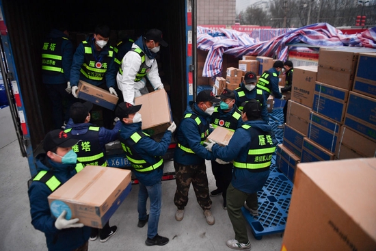 ↑1月6日，西安市雁塔区退役军人志愿突击队队员搬运防疫物资。