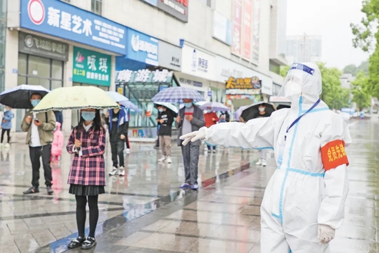 5月18日，邻水县再次开展全域全员核酸检测，市民打着雨伞前来进行核酸检测。广安日报赴邻水采访组 范聪/图