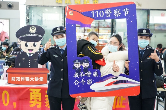南京铁路公安处联合南京市公安局公交治安分局在南京火车站举行迎接“中国人民警察节”活动,民警和旅客在活动上合影(2022年1月7日摄)。新华社记者 季春鹏 摄