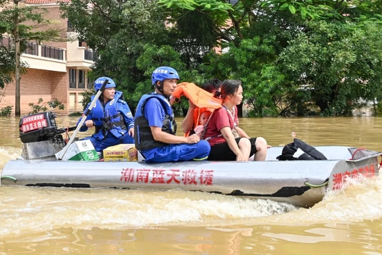 6月22日,广东省清远市英德市,蓝天救援队队员使用冲锋舟转移浛洸镇居民。