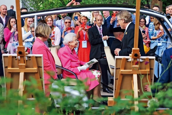 2022年5月23日，英国伦敦，英国女王伊丽莎白二世参观切尔西花展。切尔西花展由英国皇家园艺学会主办，是英国最盛大也是全球最著名的园艺博览会之一。本届花展为了纪念英国女王伊丽莎白二世登基70周年，特推出一种名为“伊丽莎白”的新品种玫瑰。图/视觉中国
