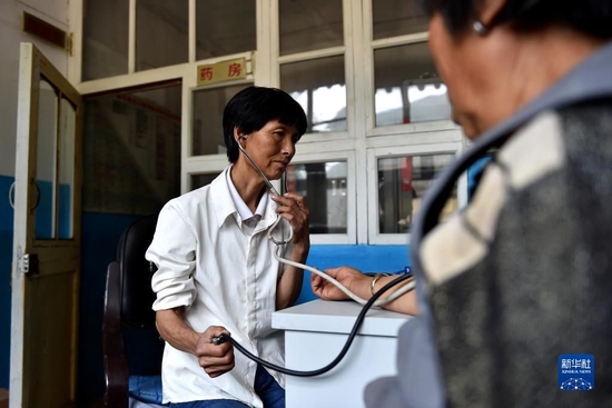 刘桂珍在山西省代县段家湾村卫生所，为一名村民测量血压（资料照片）。新华社记者 詹彦 摄