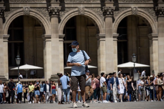 2022年7月8日，一名佩戴口罩的男子走在法国巴黎卢浮宫广场。新华社发（奥雷利安·莫里萨尔摄）