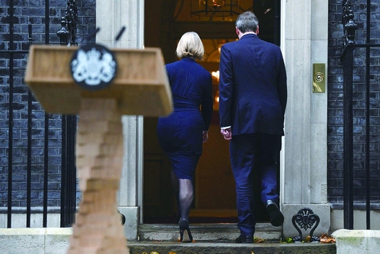 当地时间20日，英国首相特拉斯（左）在发表辞职声明后，与丈夫一起黯然走进唐宁街10号。 （视觉中国）