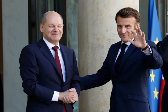 10月26日，在法国巴黎，法国总统马克龙（右）在总统府爱丽舍宫迎接德国总理朔尔茨。新华社发（里特·埃斯摄）