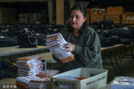 当地时间2022年11月9日，美国加利福尼亚州，在圣安娜的奥兰治县选民登记处的邮寄选票处理中心，Lisa Perez在邮件投票处理过程中整理装有选票的信封。 图源 视觉中国