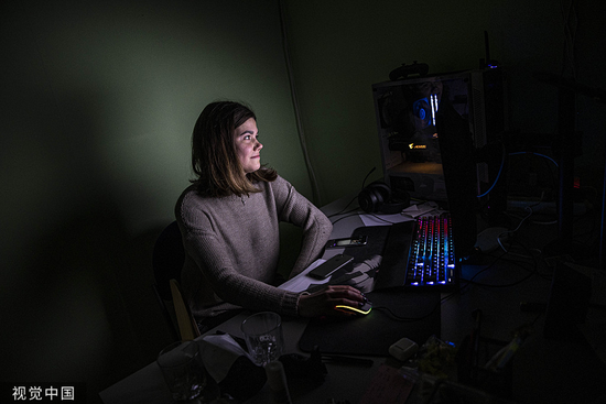 当地时间2022年11月21日，乌克兰基辅，一名妇女在接受采访时，使用一台由发电机供电的电脑。人民视觉  资料图