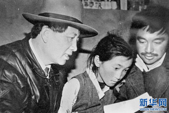 在西藏工作期间,孔繁森(左)在辅导藏族儿童读书(资料照片)。新华社发