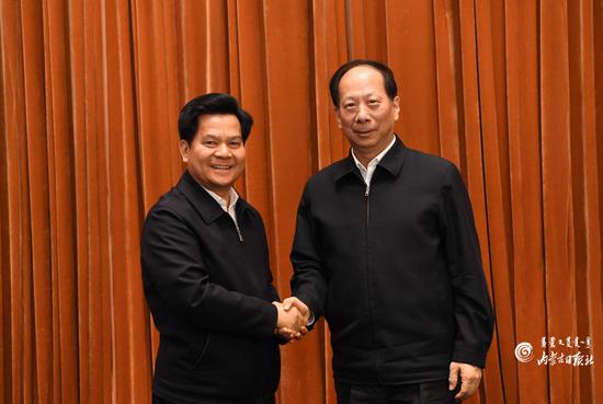  10月25日下午，石泰峰同志（右）和李纪恒同志在全区领导干部会议上亲切握手。  内蒙古日报社融媒体记者  袁永红 摄