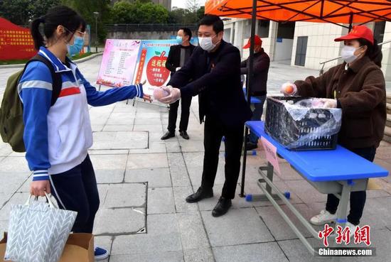 4月7日,福州第七中学,学校为返校上课的高三年级门生每人奉上一颗寓意平安全安,硕果累累的苹果。张斌 摄