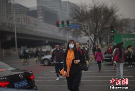 资料图:北京市民在雾霾中出行。 中新社记者 刘关关 摄