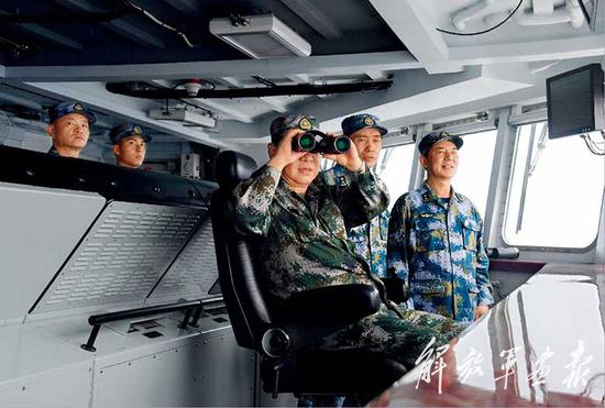 2018年4月12日，中央军委在南海海域隆重举行海上阅兵，展示人民海军崭新面貌，激发强国强军坚定信念。中共中央总书记、国家主席、中央军委主席习近平检阅部队并发表重要讲话。这是检阅完海上编队后，习近平前往检阅舰驾驶室，透过舷窗观看受阅编队航行情况。图片来源：解放军画报