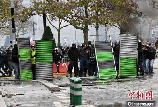 图为示威者使用路障与警方对峙,并向警方投掷石块等杂物。 李洋 摄