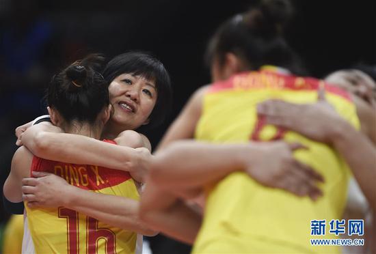 2016年8月20日,中国队主教练郎平(左二)在2016年里约奥运会女子排球决赛战胜塞尔维亚队夺冠后与队员拥抱庆祝。新华社记者李尕摄