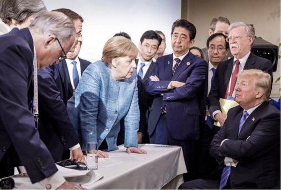 (图:2018年6月,在七国集团首脑会议(G7)上,美国向它的欧美盟友挥起了关税大棒,造成了美国与其他六国的“严重分歧”。这张现场新闻照片,被网友戏称“六大门派围攻光明顶”。)