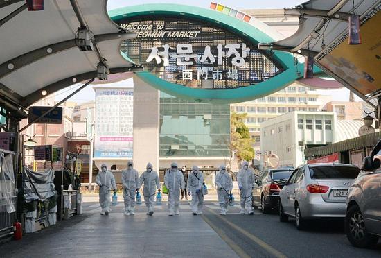 ↑2月23日，在韩国大邱，受疫情影响而临时休业的商家工作人员在西门市场进行防疫消毒。新华社发