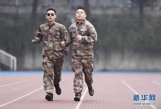 1月2日，“排雷英雄战士”杜富国（左）和战友在陆军军医大学操场上跑步。新华社记者 王全超 摄
