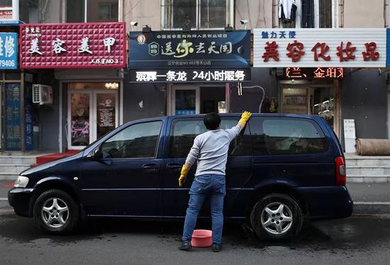 　12月1日，辣椒在店门口擦洗自己的车，第二天要当出殡的头车。