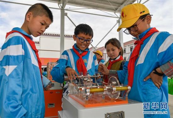 几名学生在拉萨市流动科技馆巡展活动现场体验科学小实验（5月24日摄）。 新华社记者 刘东君 摄