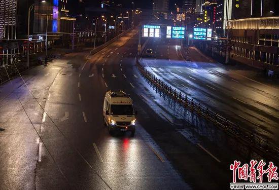 2月2日晚，一辆救护车在武汉空旷的街头行驶。中青报·中青网记者  李峥苨/摄