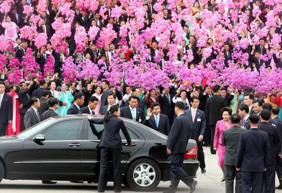 2007年10月2日,在朝鲜首都平壤“四・二五”文化会馆前广场,朝鲜群众手持花束,欢迎来访的韩国总统卢武铉。(新华社发)