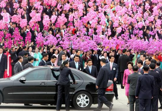 2007年10月2日，在朝鲜首都平壤“四・二五”文化会馆前广场，朝鲜群众手持花束，欢迎来访的韩国总统卢武铉。（新华社发）