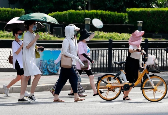 7月14日,上海街头的路人“各显神通”躲避炙热的阳光。图/中新图片网