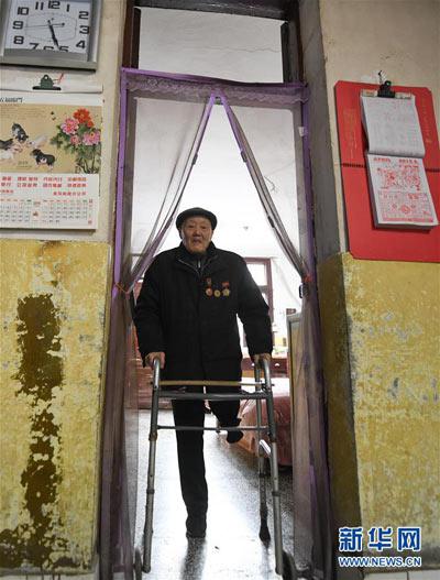 左腿截肢的张富清依靠支撑架在家里活动(3月31日摄)。新华社记者 程敏 摄