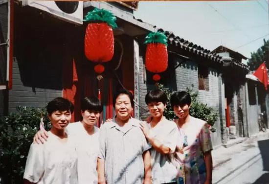 1990年代，创始人刘桂仙与当时悦仙餐馆的服务员合影，当时服务员多为自己的亲戚。新京报记者 彭子洋 翻拍