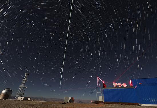 在西藏阿里观测站,“墨子号”量子科学实验卫星过境,科研人员在做实验(2016年12月10日摄,合成照片)。新华社记者 金立旺 摄