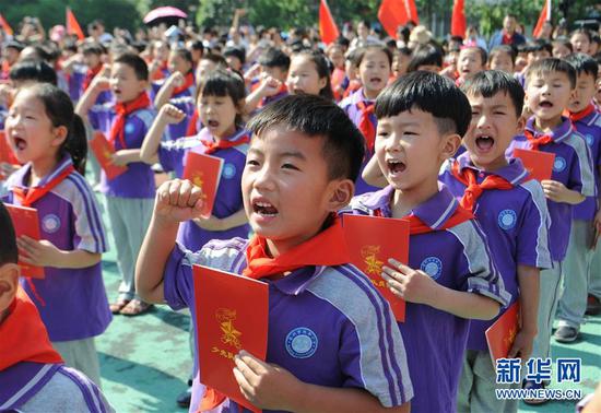 在2017年5月26日安徽省亳州市谯城区风华小学举行的入队仪式上，孩子们在宣读入队誓词。新华社发（张延林 摄）