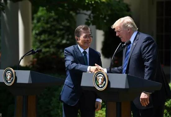 2017年6月30日，在美国华盛顿白宫，美国总统特朗普（右）与韩国总统文在寅在联合新闻发布会上握手。新华社记者殷博古摄